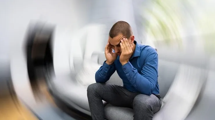 Man holding head in discomfort, illustrating brain fog and headaches
